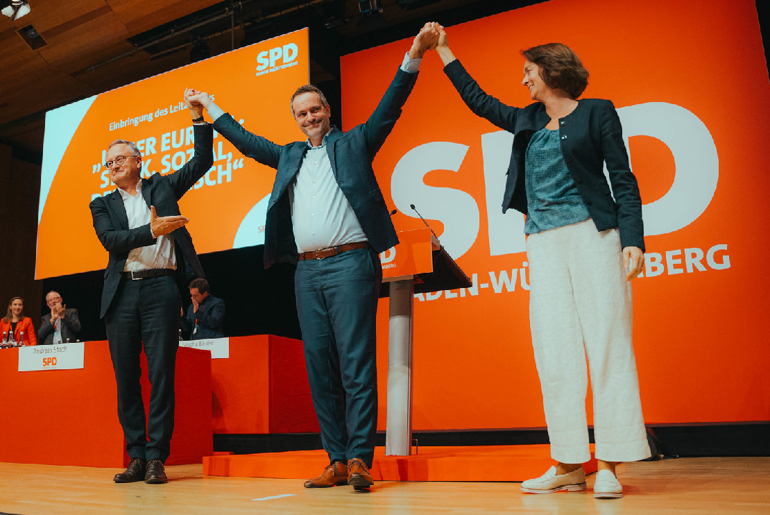 Andreas Stoch, Rene Repasi und Katarina Barley freuen sich auf der Bühne beim Europaparteitag der SPD Baden-Württemberg